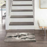 Entryway with Nourison Twilight Grey Ivory Black Rug, stairs, wood floors, and white bench.