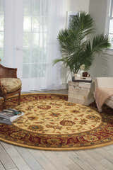 Sunlit room with round Nourison Jaipur Light Gold rug, floral pattern, rattan chair, and neutral furniture.