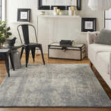 Living room scene with a Nourison Sahara Ivory/Slate rug, sofa, black chairs, and white brick wall.