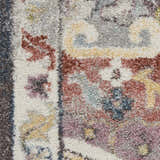 Close-up of Nourison Soraya Charcoal Multi rug. Colorful floral pattern in taupe, red, purple, and yellow hues. Soft texture.