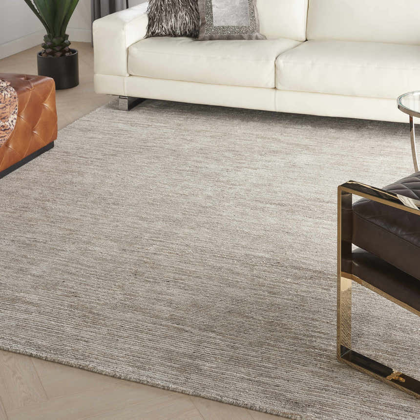 Modern living room with white sofa and Nourison OCEAN Sand area rug in sandstone color.