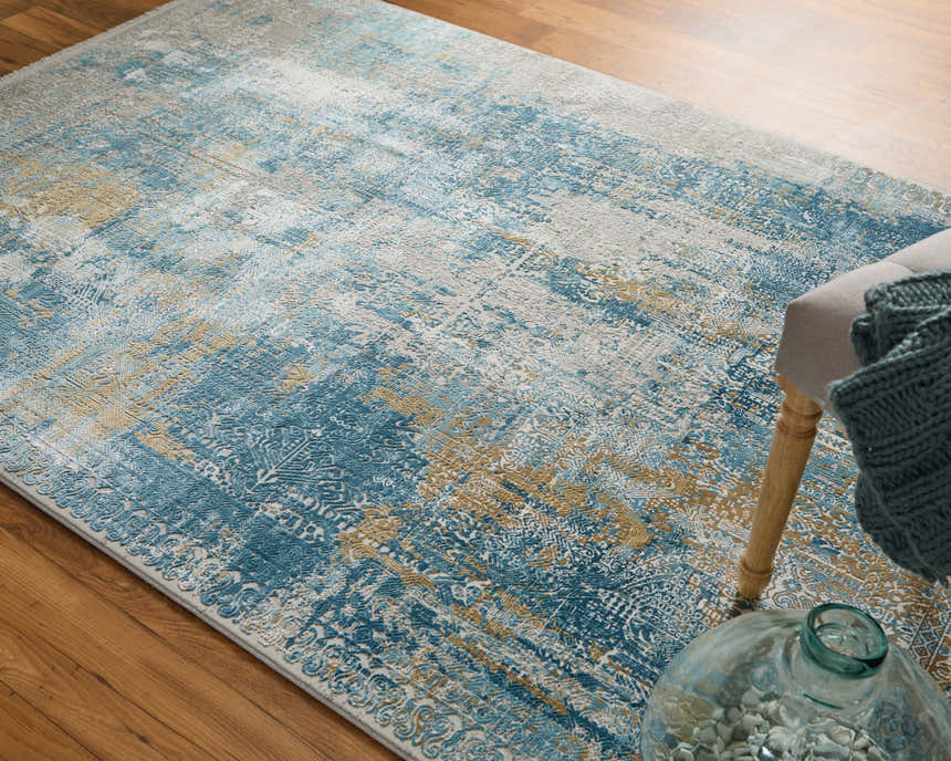 Close-up of Feizy Cadiz rug: modern abstract design in blue, gray, and gold on wood floor. Contemporary style. Roomscene-Rectangle
