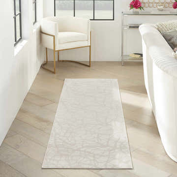 Modern living room with white sofa and Nourison Desire Beige rug on wood floor.