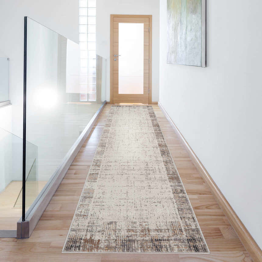 Bright hallway with a Nourison Elation Ivory Grey runner rug, wood floors, glass railing, and white walls.