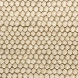 Close-up of the beige DKNY Pure Knots rug, featuring a textured, looped pile construction.