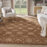 Living room with a Nourison Silk Pointe Brown Vintage rug, white sofa and chair, and natural light.