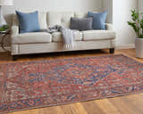 Living room scene with Feizy Rawlins red, tan, and blue rug, cream sofa, blue pillows, and wood floors. Roomscene-Rectangle