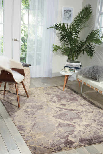 Sunlit room with a Nourison Somerset Grey rug, mid-century chair, and tropical plant creating a modern, airy feel.