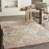 Living room scene with a Nourison Soraya Terracotta Multicolor rug, chair with throw, fireplace, and wood floors.