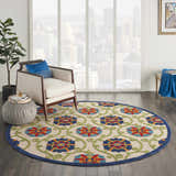 Bright living room with a round Nourison Aloha Blue Multicolor rug, chair, and city view.