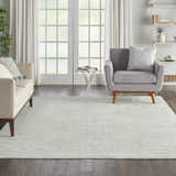 Living room with a Nourison Jubilant Ivory Green rug, light sofa, gray chair, and white french doors. Farmhouse style.