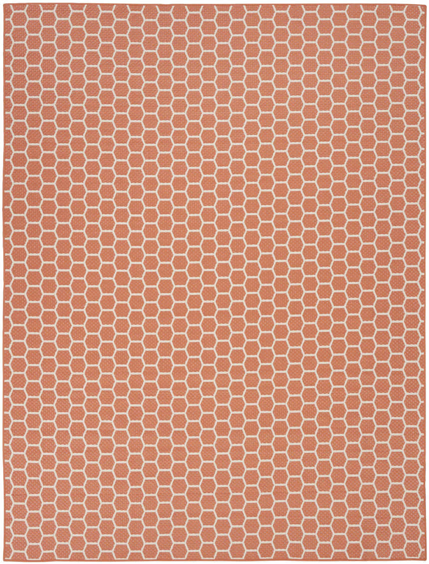 Close-up of the Nourison Twist Reversible Coral Modern Area Rug featuring a honeycomb pattern in coral and white.