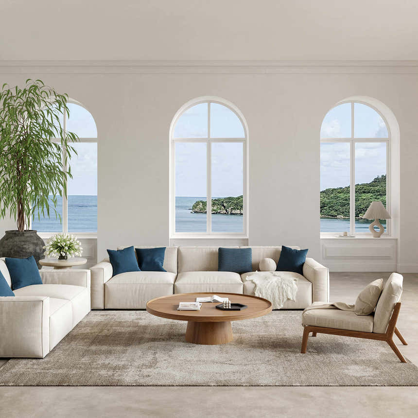 Coastal living room with a Nourison Harmony Silver Grey rug, beige sofas, wood table, and ocean view.