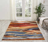 Bright sunroom with Nourison Chroma Lava Flow rug, featuring red, gold, and blue abstract design.