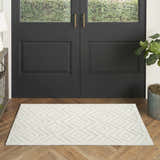 Entryway with black door and Nourison Versatile Ivory White Modern Area Rug with geometric diamond pattern on wood floor.
