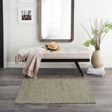 Entryway with bench, mirror, and Nourison Natural Jute Sage rug on gray wood floor. Farmhouse style.