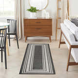 Dining room with a Nourison Horizon Black Modern Area Rug runner, wood accents, and neutral tones.