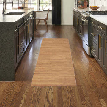 Modern kitchen with dark cabinets and Nourison Essentials Copper runner rug on hardwood floors.