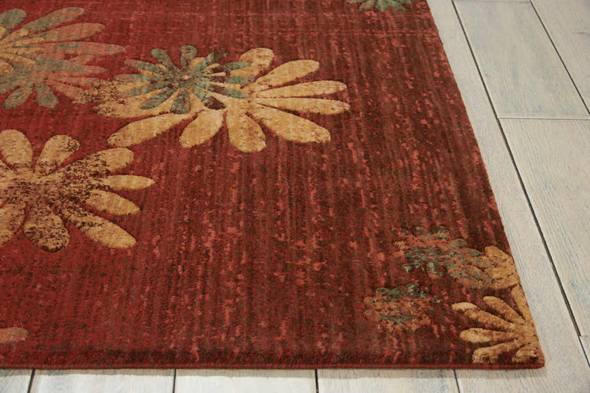 Close-up of the Nourison Radiant Impression Flame rug, featuring a floral design in flame, gold, and teal tones.