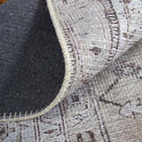 Close-up of Feizy Percy rug showing tan, ivory, and gray medallion pattern, texture, and machine-made construction. Fold