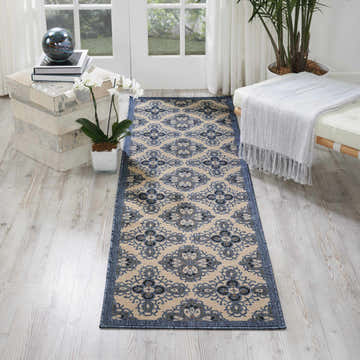 Entryway with Nourison Caribbean Ivory Blue rug runner, light wood floors, bench, and plant.