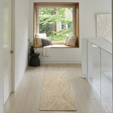 Hallway with Nourison Graceful Taupe runner rug, window seat, and modern decor. Ivory and neutral tones create a calming space.