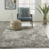 Modern living room with Michael Amini MA90 Uptown Grey rug, blue chair, knit pouf, and city view.