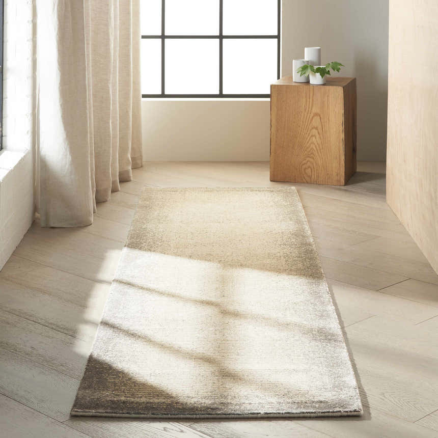 Hallway scene with a Calvin Klein Home Maya Vapor rug, wood floors, linen curtains, and natural light.