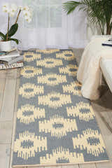 Living room scene with a taupe Barclay Butera Prism Slate runner rug, white sofa, and plants.