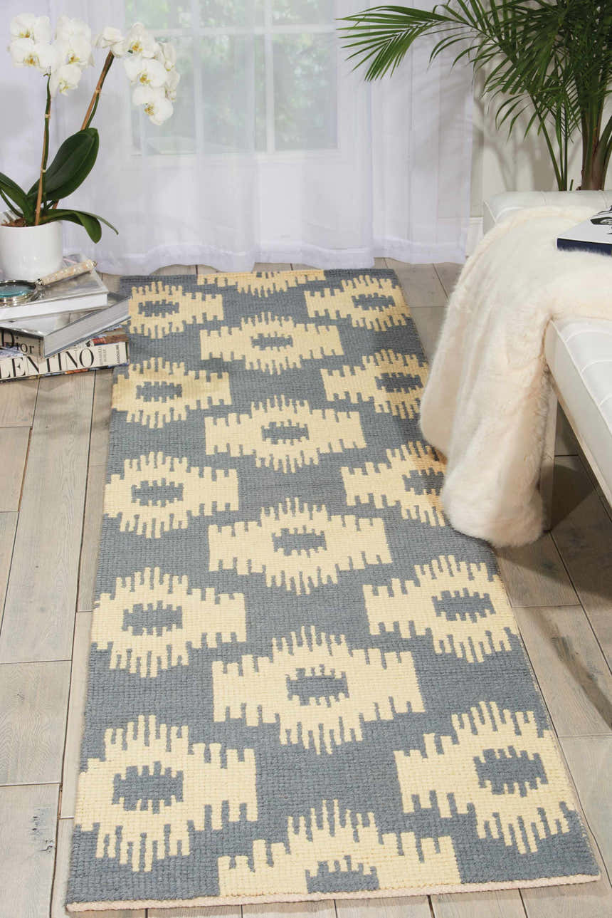 Living room scene with a taupe Barclay Butera Prism Slate runner rug, white sofa, and plants.