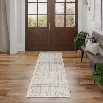 Entryway with a Nourison Andes Ivory Grey rug, wood floors, bench, and double doors. Scandinavian style.