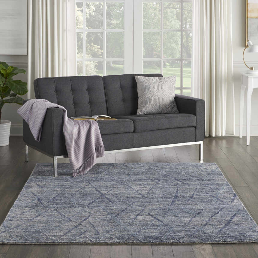 Living room scene with gray sofa and Nourison OCEAN Indigo modern rug in purple hues.