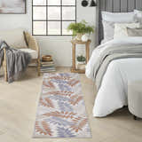 Bedroom scene with Nourison Aloha Blue Mocha runner rug, rattan chair, and gray accents.