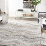 Modern living room with a Nourison Elation Grey Ivory rug, white sofa, and decorative wall art.