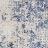 Close-up of Nourison Silky Textures Ivory/Blue rug. Abstract pattern with soft blue and ivory tones, plush texture.