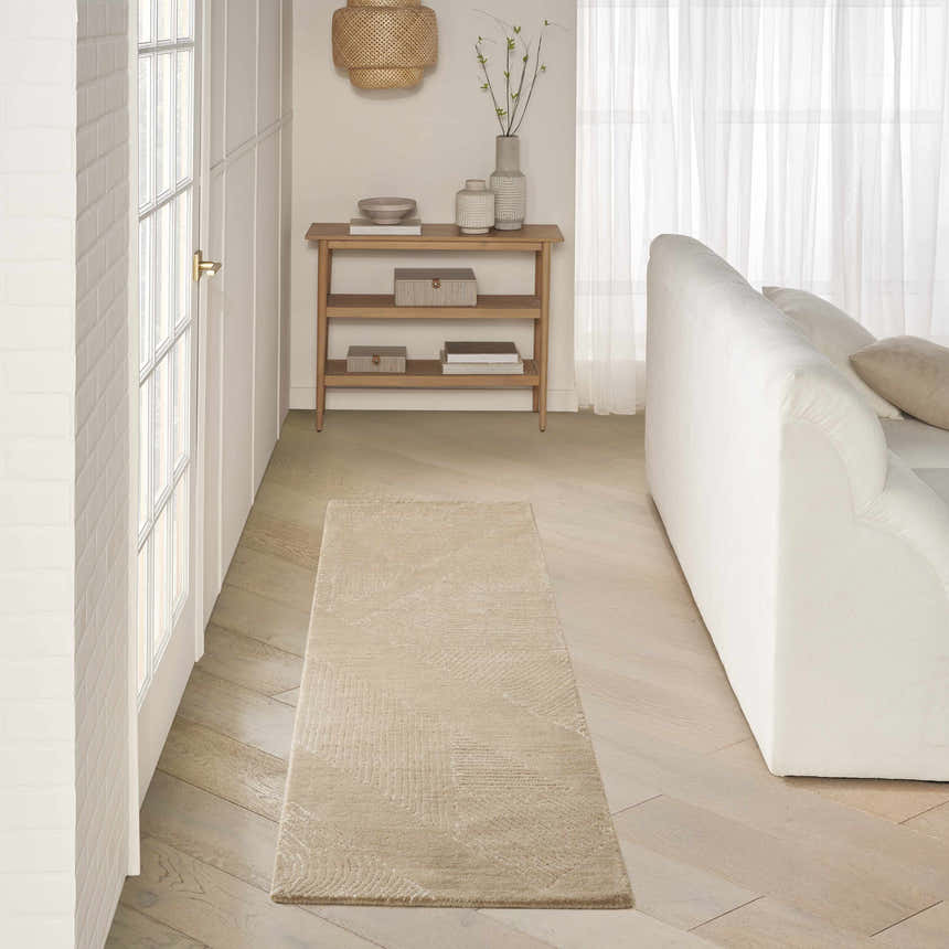 Hallway with DKNY Pure Patterns Camel rug, white sofa, wood floors, and console table.