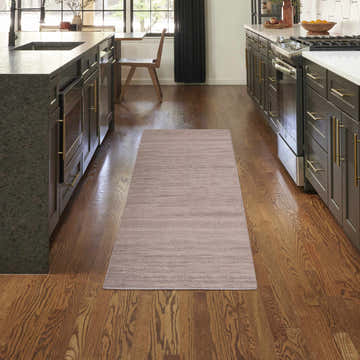 Modern kitchen with a Nourison Essentials Natural rug runner in brick red on hardwood floors.