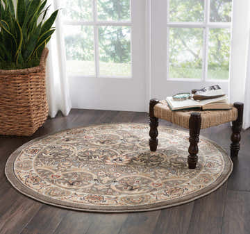 Bright room with a round Nourison Walden Grey rug, jute stool, and dark wood floors.