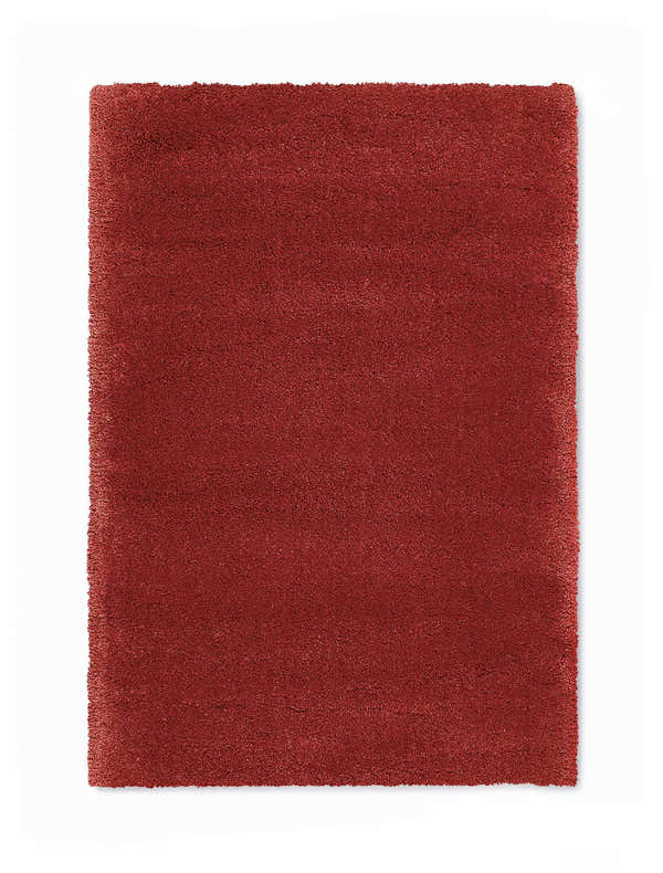 Close-up of a plush, burgundy Calvin Klein Brooklyn area rug. The rug has a shag texture and a rectangular shape.