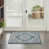 Entryway scene with Nourison Passion Turquoise Grey rug, white french doors, and wood floors.