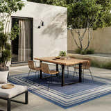 Outdoor patio scene with a dining table on a Nourison Horizon Denim Modern Area Rug.
