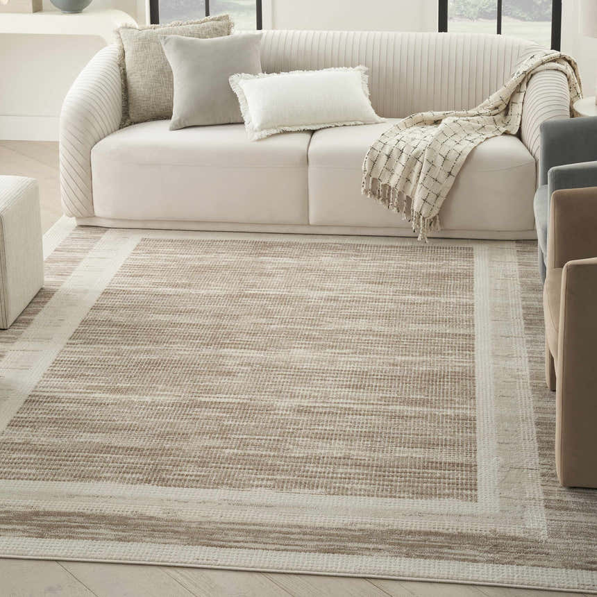 Modern living room with a Nourison Serenity Home Mocha Ivory rug, cream sofa, and neutral accents.