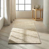 Minimalist room scene with a Calvin Klein Mesa Gypsum rug, wood floors, and neutral decor.