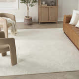 Living room with a chestnut leather sofa, beige chairs, and Nourison Avra Ivory Modern Area Rug.