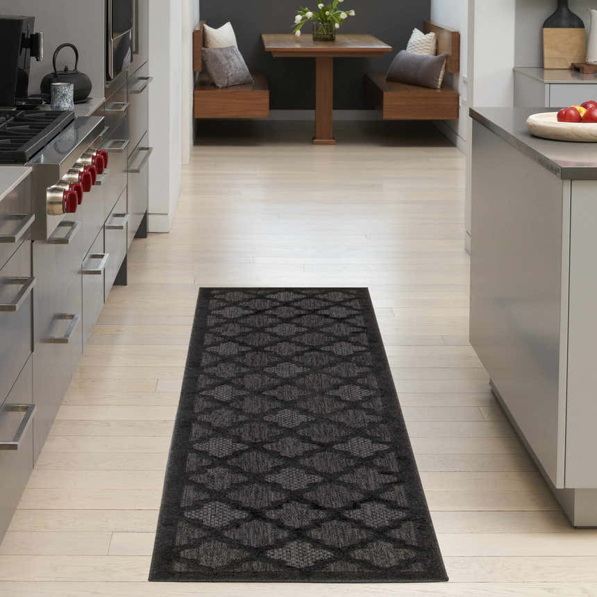 Modern kitchen scene with a Nourison Easy Care Charcoal Black runner rug on light wood floors.