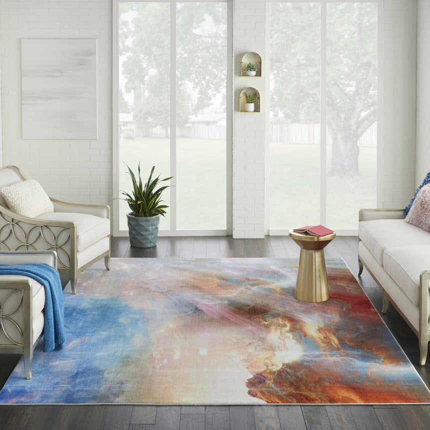 Living room with a Nourison Le Reve Multicolor rug, white sofa and chairs, and dark wood floors.