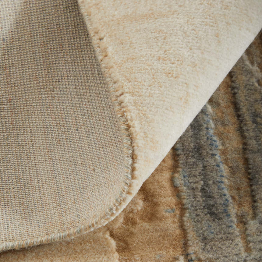 Close-up of the Feizy Jaxson Tan/Brown/Gray Area Rug showing abstract geometric patterns and textures. Fold