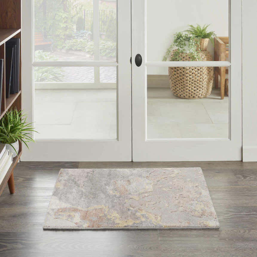 Entryway with Nourison Silk Shadows Silver rug, wood floors, and white double doors to a garden.