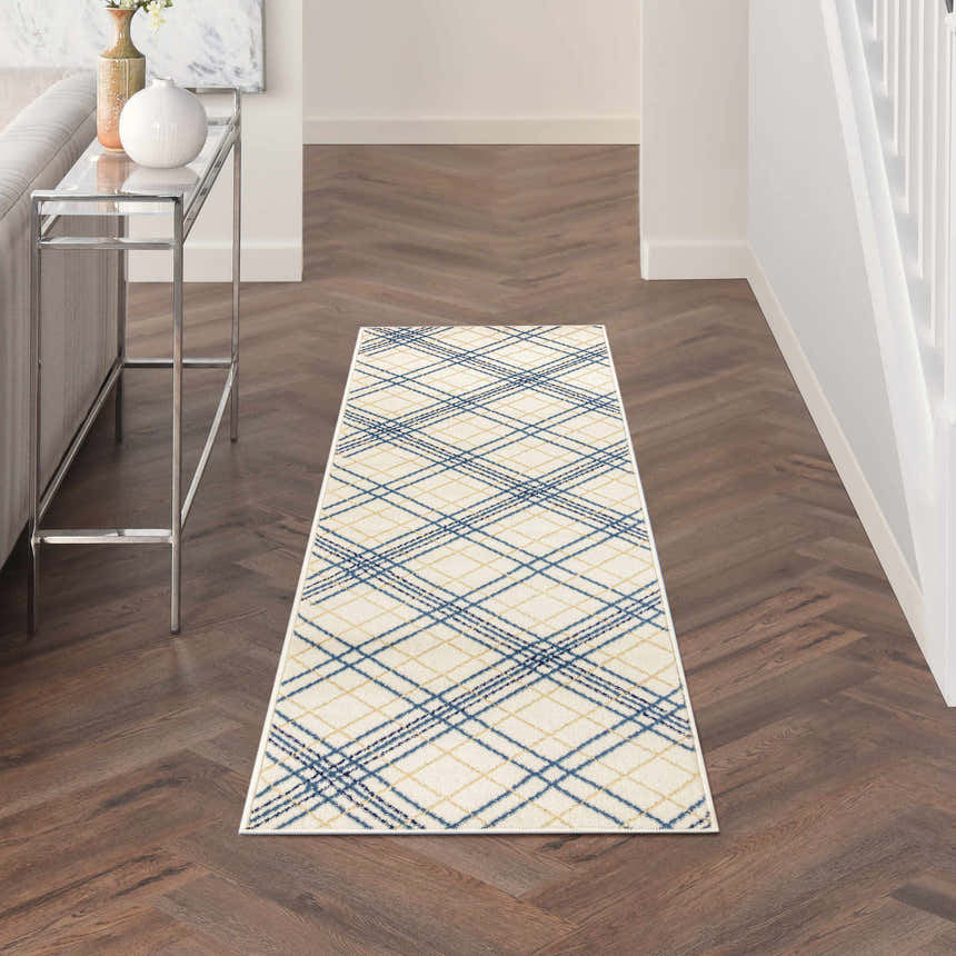 Hallway scene with Nourison Jubilant Ivory Navy rug runner on wood floor. Farmhouse style with console table and white walls.