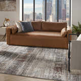 Modern living room with brown leather sofa and Nourison Tangra Multicolor Area Rug. City view.
